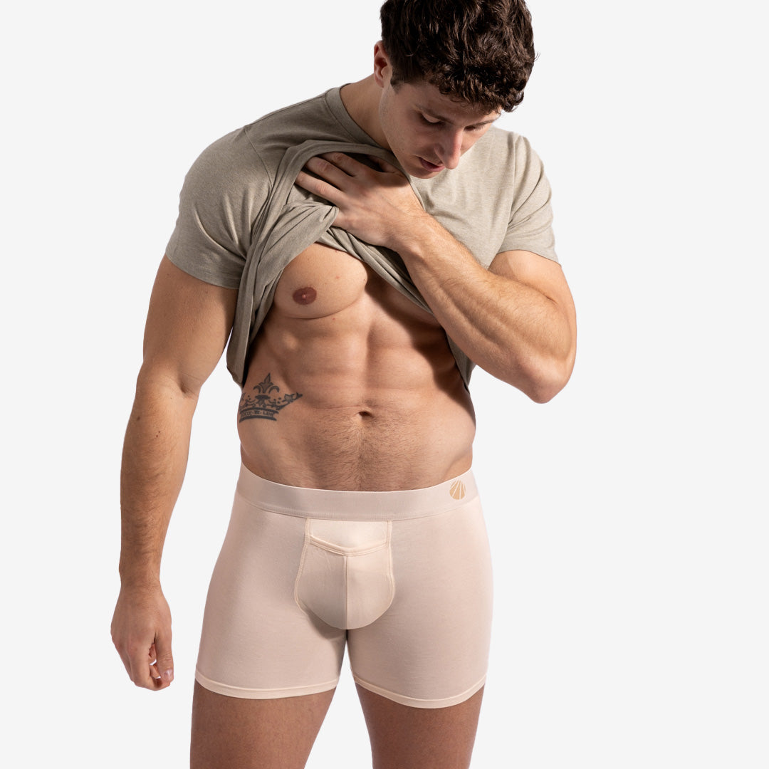 Man wearing beige boxer briefs with a plain background