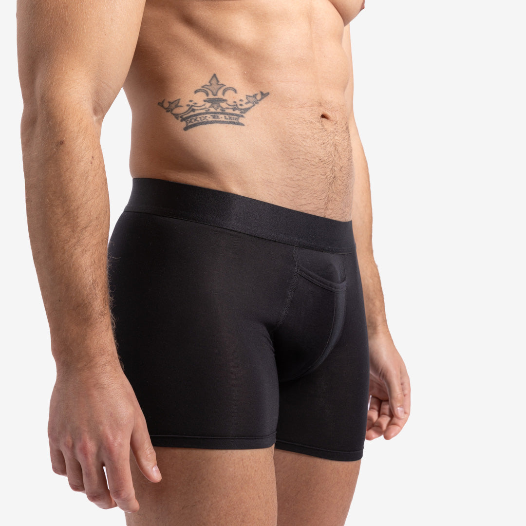 Black boxer briefs worn by a person on a plain background