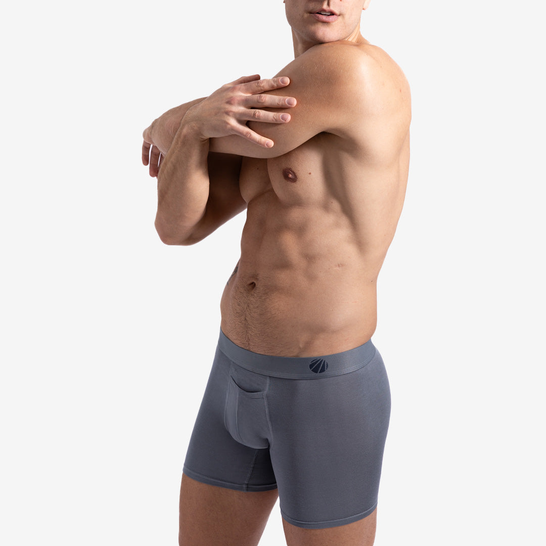 This image displays the Eco-Luxe Boxer Brief, designed for superior comfort and freshness throughout the day. Modelled by a fit male, the boxer brief is grey in color, showcasing a sleek and modern design.