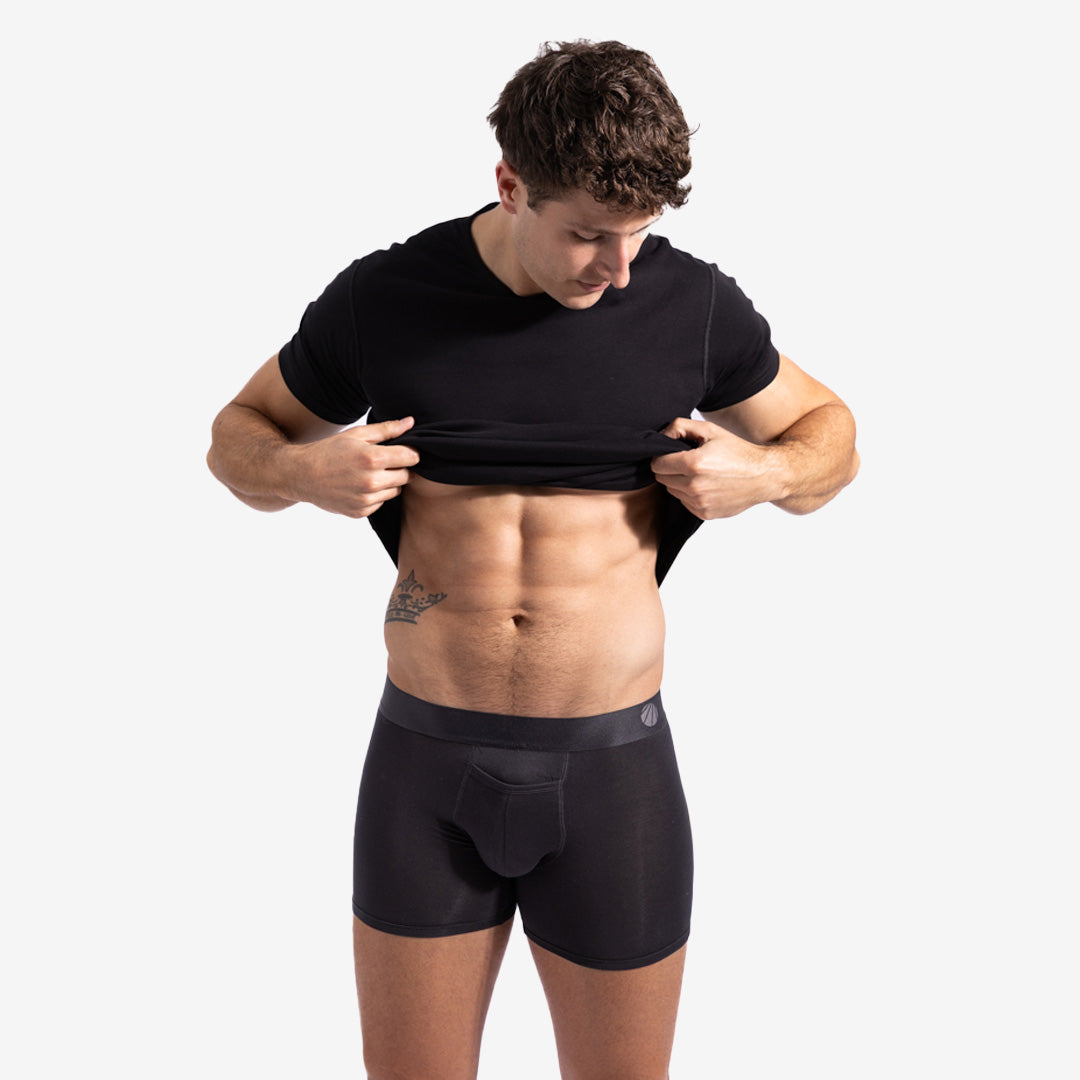 Man wearing black t-shirt and underwear on a white background